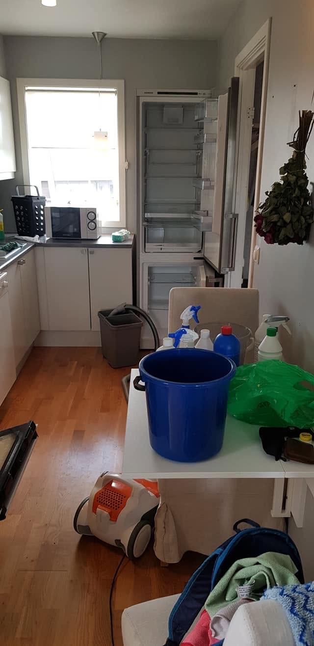 Et kjøkken i Drammen med åpne hvitevarer og rengjøringsutstyr mens flyttevasken pågår.