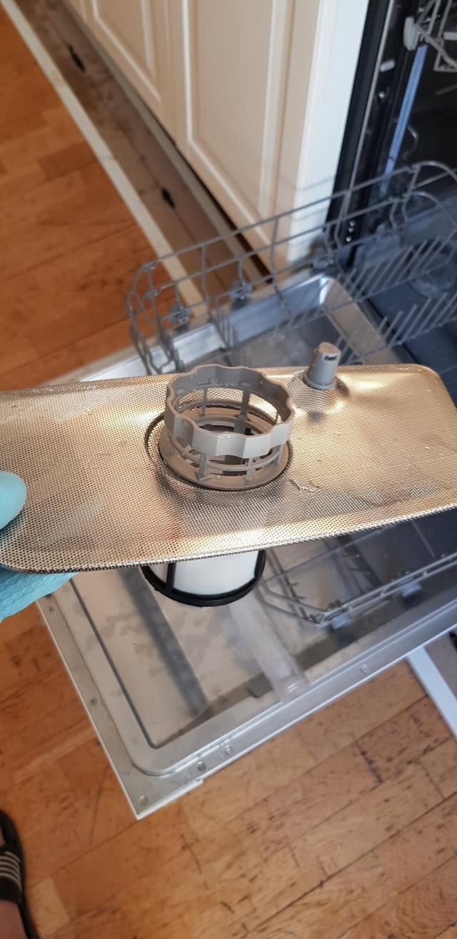 En filterdel er løftet ut av en åpen oppvaskmaskin under arbeidet i Lillestrøm.