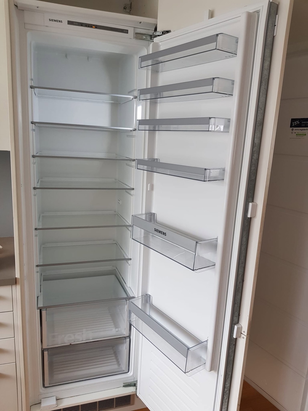 Et åpent kjøleskap med rengjorte hyller og skuffer etter arbeid i Oslo.