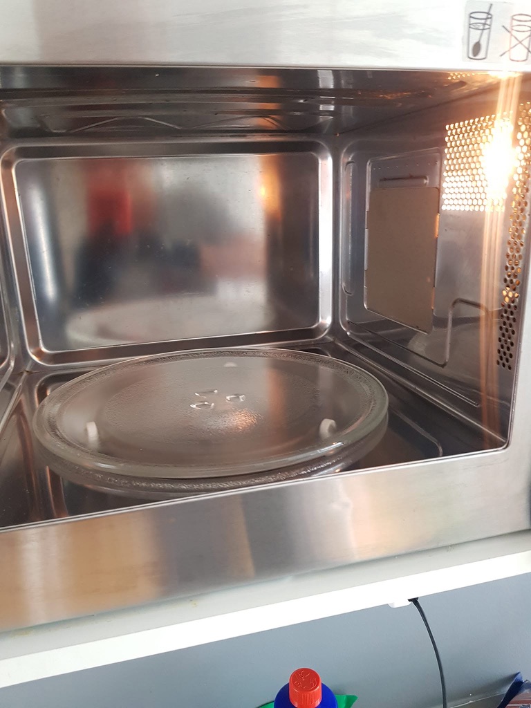 Den samme mikrobølgeovnen med rengjorte innvendige flater etter arbeidet.