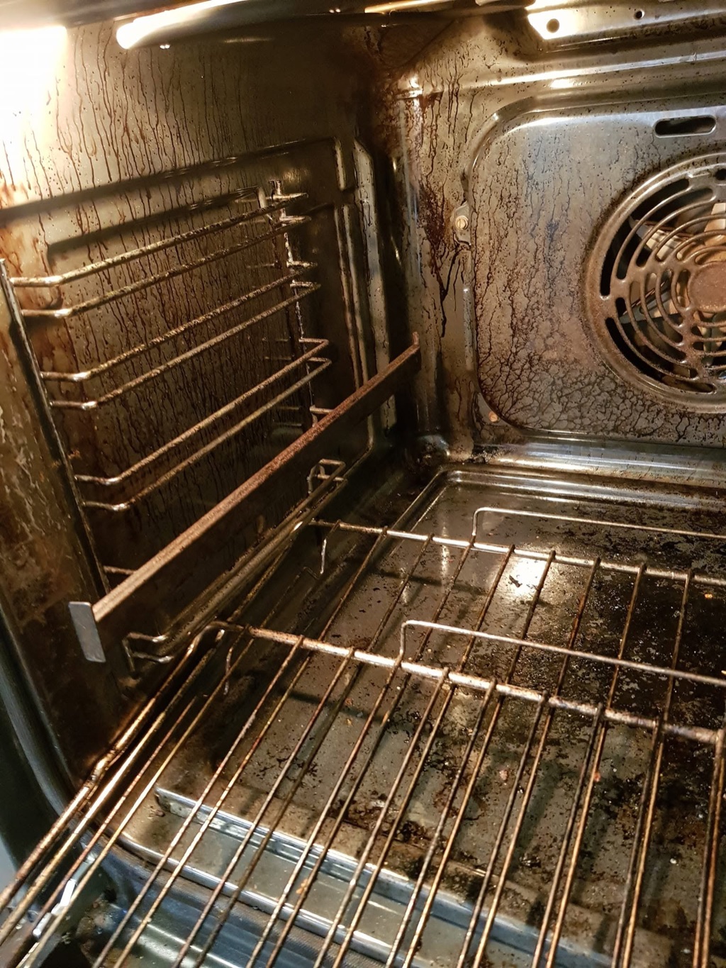 En stekeovn med rister før grundig rengjøring.