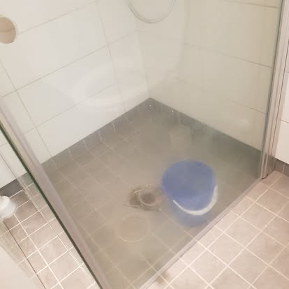 En dusjsone med bøtte under rengjøring.