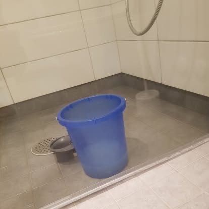 En dusjsone med bøtte mens rengjøringen pågår.